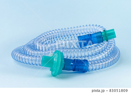 Tubing for CPAP or BIPAP machine with green filter isolated on blue background.  83051809
