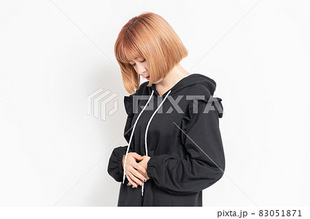手でお腹を押さえている若い女性 83051871