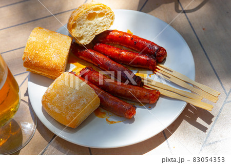 Mildly spiced grilled mini sausages chistorra. Tapa from Basque Country cuisine 83054353