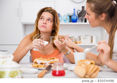 woman with cake and calming sad friend 83054496