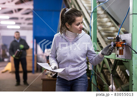 Woman supervising sensors of machine of olive oil pressing 83055013