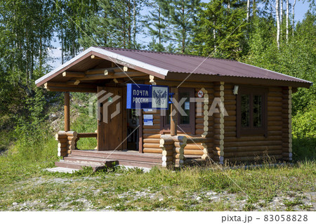 Ruskeala, Russia - July 10, 2021: Wooden house with the signboard "Russian Post" in Russian on the facade Ruskeala, Russia - July 10, 2021: Wooden house with the signboard "Russian Post" in Russian on the facade 83058828