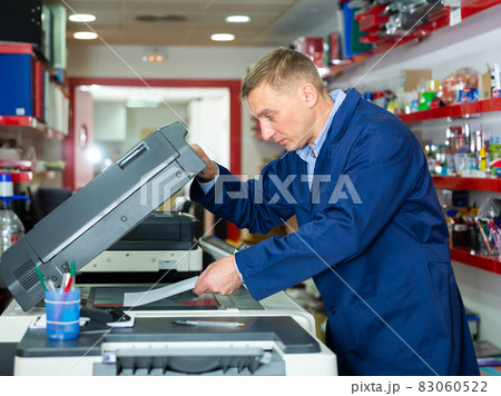 Service engineer using a copy machine Service engineer using a copy machine 83060522