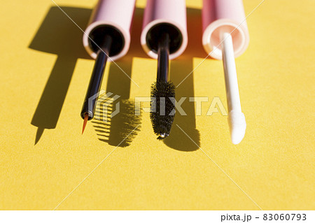 Makeup brushes on a bright yellow background with sharp shadows of sun. Cosmetics application and face care concept. 83060793