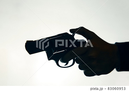 Silhouette of man's hand with revolver on white background. Silhouette of man's hand with revolver on white background. 83060953