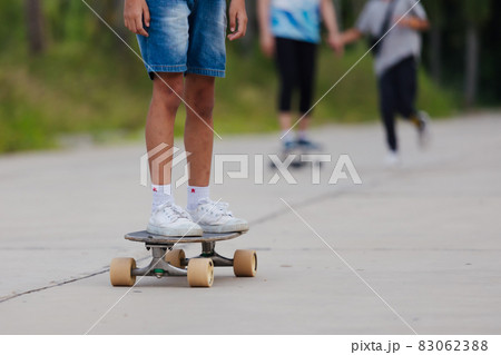 Asian child girl learning to skateboard outdoors. Kid having fun and playing skateboard on the road at the day time. Kid activity and extreme sport concept. Asian child girl learning to skateboard outdoors. Kid having fun and playing skateboard on the road at the day time. Kid activity and extreme sport concept. 83062388