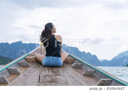 Adventure lifestyle vacationer relax concept. Traveler young woman holding own hair while sitting Adventure lifestyle vacationer relax concept. Traveler young woman holding own hair while sitting 83064887