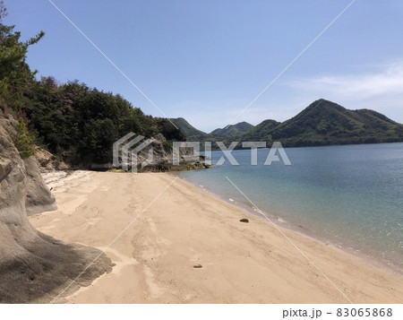 《うさぎの島（大久野島）砂浜に打ち寄せる海の波打ち際と山と青空の風景》（広島県　竹原市） 83065868