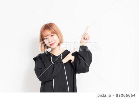 指でポイントを示す若い女性 83066664