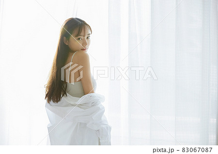 窓辺に立つ若い女性のナチュラルなビューティーポートレート 83067087