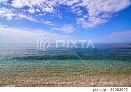 Tropical Asian beach with white sand, turquoise ocean against blue sky with clouds 83068605