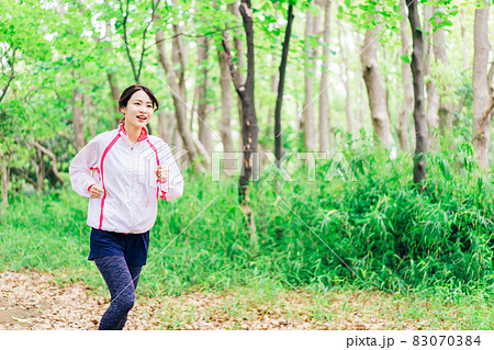 スポーツウェアを着てランニングをする若い女性 83070384