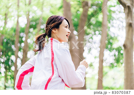 スポーツウェアを着てランニングをする若い女性 スポーツウェアを着てランニングをする若い女性 83070387