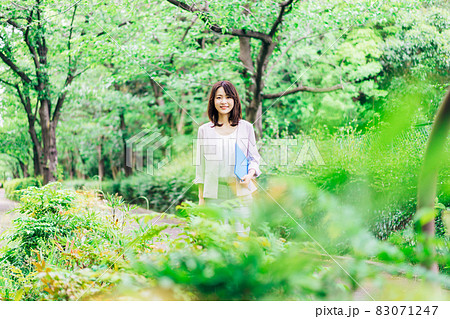 書類を持って歩く若いビジネスウーマン 83071247