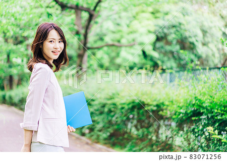 書類を持って歩く若いビジネスウーマン 83071256