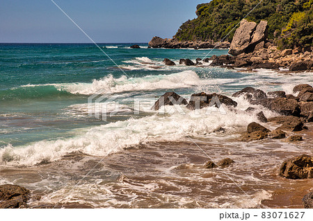 Sea waves crashing onto rocks with water splashes. Corfu island, Greece. Sea waves crashing onto rocks with water splashes. Corfu island, Greece. 83071627