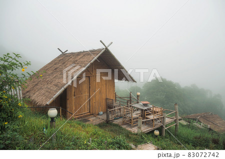 Wooden thatched hut resort in foggy on hill in tropical rainforest Wooden thatched hut resort in foggy on hill in tropical rainforest 83072742