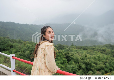 Asian woman smiling among the foggy mountain on rainy season 83073251