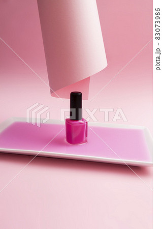 Pink nail polish dipped in pink liquid and pink background. Aesthetic and minimalism concept. 83073986