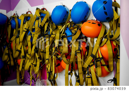 Helmets and climbing equipment hanging on the wall 83074039