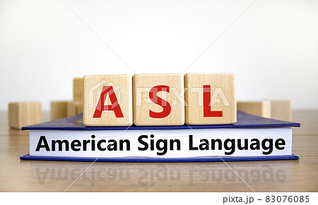 ASL, american sign language symbol. Wooden cubes on book with words 'ASL, american sign language'. White background. Medical and ASL, american sign language concept. Copy space. ASL, american sign language symbol. Wooden cubes on book with words 'ASL, american sign language'. White background. Medical and ASL, american sign language concept. Copy space. 83076085