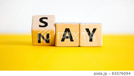 Say nay symbol. Turned a cube, changed the word 'say' to 'nay'. Beautiful yellow table, white background. Copy space. Business, motivation and say nay concept. 83076094