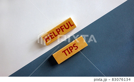 Helpful tips symbol. Wooden blocks with words 'Helpful tips'. Beautiful white and blue background. Business and helpful tips concept. Copy space. 83076134