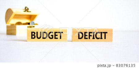 Budget deficit symbol. Concept words 'budget deficit' on wooden blocks on a beautiful white background, small chest with coins. Business and budget deficit concept, copy space. 83076135