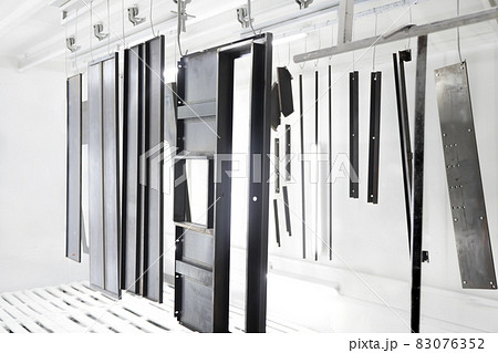 Factory metal surface coating paint in painting chamber. Powder coating of metal parts in spray booth. Coating industry painting metal products in paint booth. Steel parts Inside industry paint garage Factory metal surface coating paint in painting chamber. Powder coating of metal parts in spray booth. Coating industry painting metal products in paint booth. Steel parts Inside industry paint garage 83076352