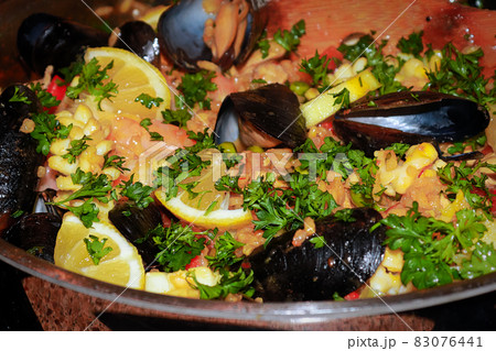 Closeup of seafood paella with lemons, mussels, and rice 83076441