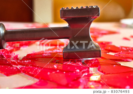 Breaking broken glass candy with a mallet Breaking broken glass candy with a mallet 83076493