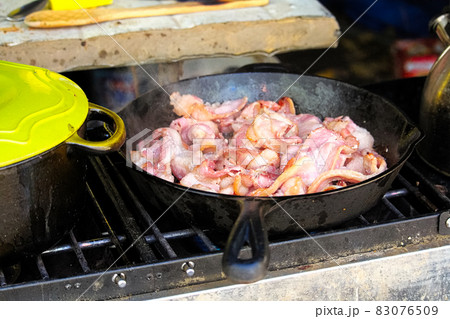 Closeup of bacon frying in a pan 83076509