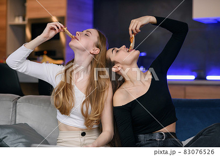 Two women having fun at home, opening pizza box, food delivery, home party Two women having fun at home, opening pizza box, food delivery, home party 83076526