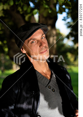 Adult handsome man in a coat and cap. Adult handsome man in a coat and cap. 83077204