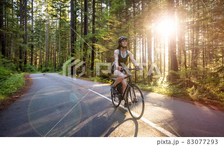 Adventurous Woman Bike Riding on a Trail in Forest Adventurous Woman Bike Riding on a Trail in Forest 83077293