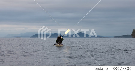 Adventurous Woman on Sea Kayak paddling in the Pacific Ocean. Adventurous Woman on Sea Kayak paddling in the Pacific Ocean. 83077300
