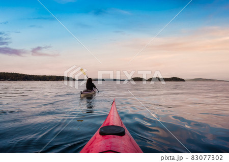 Adventurous Woman on Sea Kayak paddling in the Pacific Ocean. 83077302