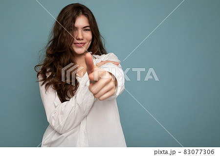 Portrait of young positive happy attractive curly brunette woman with sincere emotions wearing 83077306
