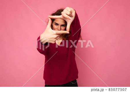 Portrait of young positive pretty brunette curly woman with sincere emotions wearing trendy pink Portrait of young positive pretty brunette curly woman with sincere emotions wearing trendy pink 83077307