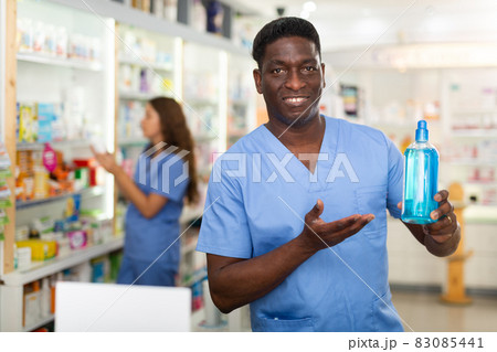 Pharmacist showing bottle with haircare product 83085441