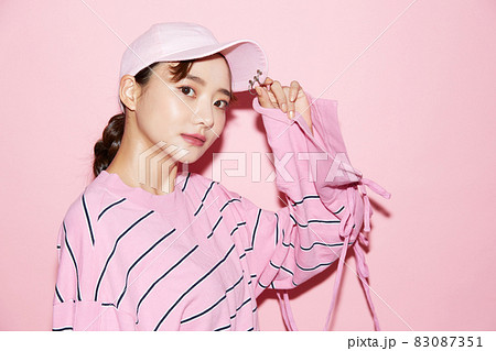 スポーティーなファッションをした若い女性のピンク背景のポートレート スポーティーなファッションをした若い女性のピンク背景のポートレート 83087351