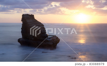 夫婦岩（婦岩、鴨川松島）の静かな海と秋の雲を照らす日の出 83088979