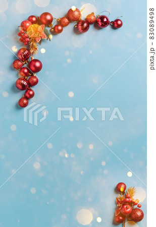 Christmas decorations red New Year's balls lined with a frame on a blue background with snowflakes, sparkles, confetti Christmas decorations red New Year's balls lined with a frame on a blue background with snowflakes, sparkles, confetti 83089498
