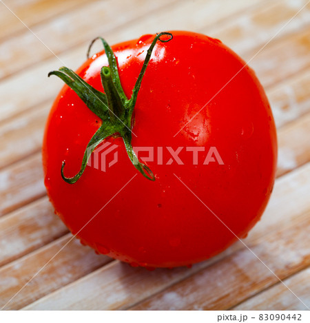 One red tomato on wooden table 83090442