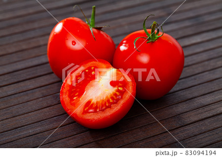 Close up of red tomatoes on wooden surface Close up of red tomatoes on wooden surface 83094194