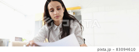 Woman sit at desk hold document read paper letter feels disappointed shocked by bad news Woman sit at desk hold document read paper letter feels disappointed shocked by bad news 83094610