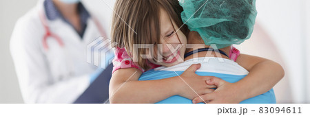 Doctor is holding little frightened girl in arms Doctor is holding little frightened girl in arms 83094611