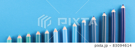 Pencils of different shades lie on blue background Pencils of different shades lie on blue background 83094614