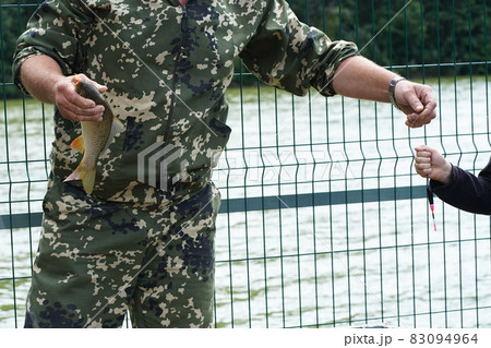 A professional fisherman holding a carp caught in his hands. Fishing as an active hobby. High quality photo 83094964
