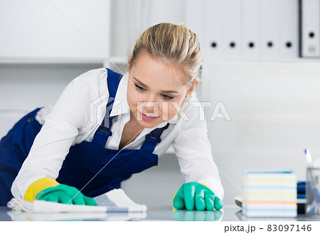 Workwoman wiping dust in office Workwoman wiping dust in office 83097146